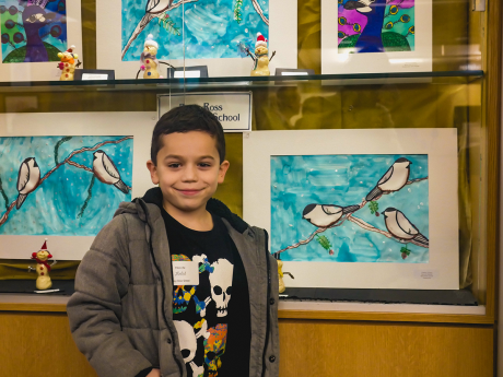 Young artist posing with his artwork